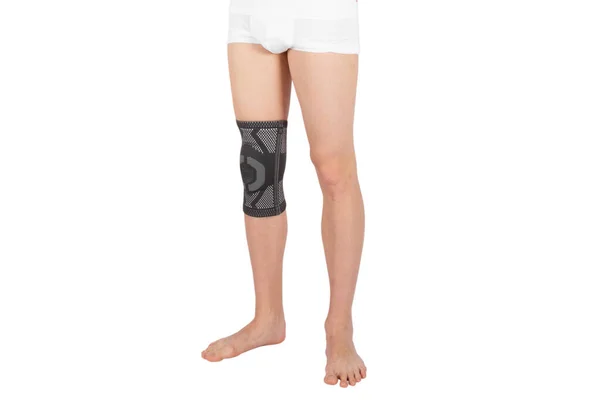 Knee Support Brace on leg isolated on white background. Orthopedic Anatomic Orthosis. Braces for knee fixation, injuries and pain. Orthotics. Foot orthosis. Knee Joint Bandage Sleeve. Elastic Sports — Stock Photo, Image
