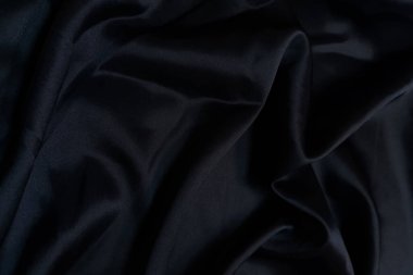 Siyah buruşuk ya da dalgalı kumaş arkaplan. Soyut keten kumaş yumuşak dalgalar. Saten, ipek ve pamuk hazineleri. Pürüzsüz zarif ipek ya da atlas lüks kumaş dokusu. Çarşaflar ya da battaniye