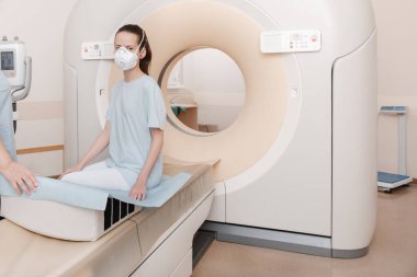 Modern hastane laboratuvarında bir hastaya tıbbi tomografi ya da MRI taraması yapın. Radyografi bölümünün içi. Beyaz odada teknolojik olarak gelişmiş ekipmanlar var. Manyetik rezonans tanılama makinesi