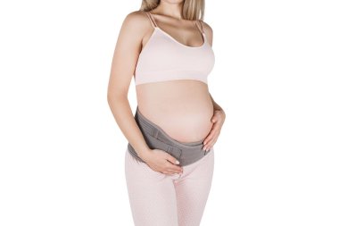 Hamilelik öncesi hamilelik kemeri takmış hamile bir kadın beyaz arka planda izole edilmiş. Bel, sırt, karın bandı. Göbek bağı. Hamilelik için karın bandı. Ortopedik karın destek kemeri