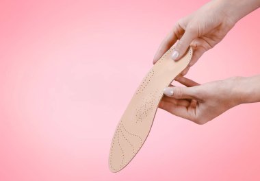 Pembe arka planda izole edilmiş ortopedik taban. Tıbbi tabanlar. Düz taban ve ayak hastalıklarının tedavisi ve önlenmesi. Ayak bakımı, ayak rahatlığı. Rahat ayakkabılar giy. Düz Ayak Düzeltme