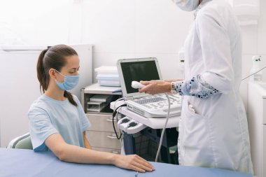 Doktor eline ultrason yapıyor. Yakın plan. Doktor ultrason sonuçlarını hastaya gösterir. Tıbbi ultrason taraması. Kas gevşemesi için botoks enjeksiyonunun rehabilitasyon uygulaması