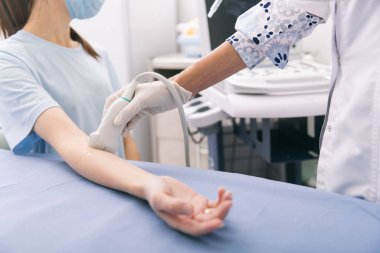 Doktor eline ultrason yapıyor. Yakın plan. Doktor ultrason sonuçlarını hastaya gösterir. Tıbbi ultrason taraması. Kas gevşemesi için botoks enjeksiyonunun rehabilitasyon uygulaması