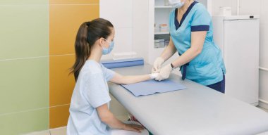 İlk yardım için bileğine dolanmış bir doktor. Hastaların ellerine bandaj uygulaması, ilk yardım konseptleri ve bilek yaralanması tedavisi. Hastanın elinde tıbbi bandaj var. Bilek ağrısı.