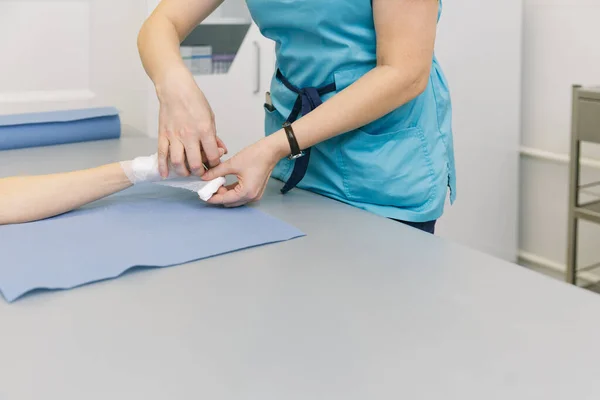 A doctor wrapped around the wrist for first aid close-up. Application of bandages on the patients hands, first aid concepts and wrist injury treatment. Medical bandage on patient hand. Wrist pain — Stock Photo, Image