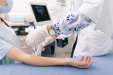 Doktor eline ultrason yapıyor. Yakın plan. Doktor ultrason sonuçlarını hastaya gösterir. Tıbbi ultrason taraması. Kas gevşemesi için botoks enjeksiyonunun rehabilitasyon uygulaması