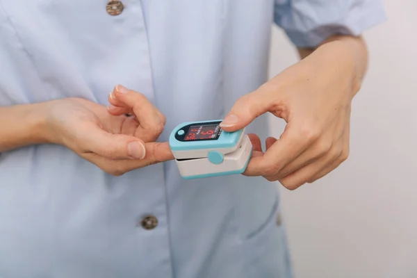 하얀 손에 의사의 손을 분리 한 채로 맥박 산화제를 실시 한다. 산소 포화도, 맥박, 산소 레벨을 측정하고. 사람들의 산소 포화도를 측정하기 위한 휴대용 디지털 장치의 개념 — 스톡 사진