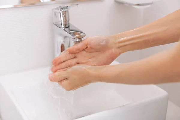 Lavar as mãos sob a torneira de água corrente. Conceito de higiene mão detalhe. Lavar as mãos esfregando com sabão para prevenção do vírus da corona, higiene para parar de espalhar o vírus da corona ou sala de lavagem pública — Fotografia de Stock