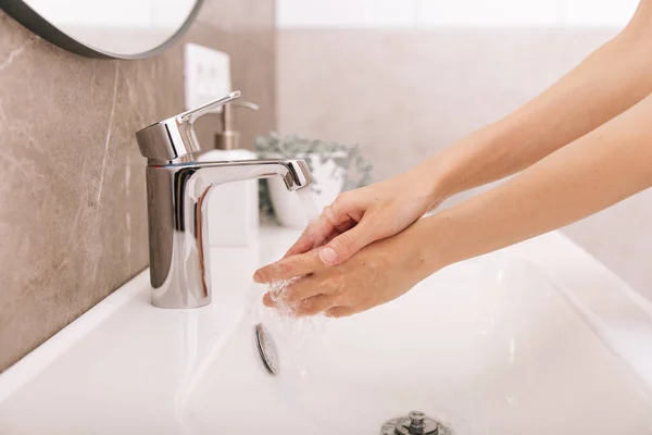Mencuci tangan di bawah keran air yang mengalir. Detail tangan konsep kebersihan. Mencuci tangan digosok dengan sabun untuk pencegahan virus korona, kebersihan untuk menghentikan penyebaran virus korona di atau ruang cuci umum — Stok Foto