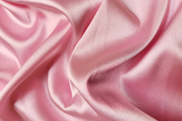 Pink crumpled or wavy fabric texture background. Abstract linen cloth soft waves. Silk atlas or stretch jacquard. Smooth elegant luxury cloth texture. Concept for banner or advertisement