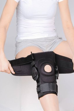 Diz Destek Kolu beyaz arka planda izole edilmiş bir bacak üzerinde. Elastik ortopedik ortopedi. Diz saplantısı, yaralanma ve ağrı için anatomik destek. Koruyucu diz eklemi bandaj kolu. Travma, rehabilitasyon.