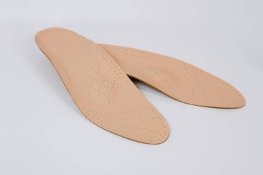 Beyaz arka planda izole edilmiş ortopedik tabanlar. Tıbbi tabanlar. Ayak bakımı. Kesik tabanlı katmanlar. Düz taban ve ayak hastalıklarının tedavisi ve önlenmesi. Ayakkabının iç tabanları
