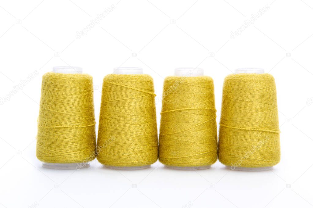 Yellow spool of thread isolated on white background. Skein of woolen threads. Yarn for knitting. Materials for sewing machine. Coil