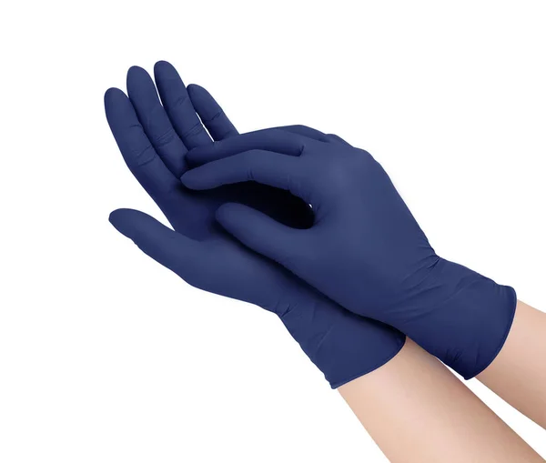 Медицинские перчатки. Две синие хирургические перчатки на белом фоне с руками. Изготовление резиновых перчаток, человеческая рука в латексной перчатке. Врач или медсестра надевают защитные перчатки — стоковое фото