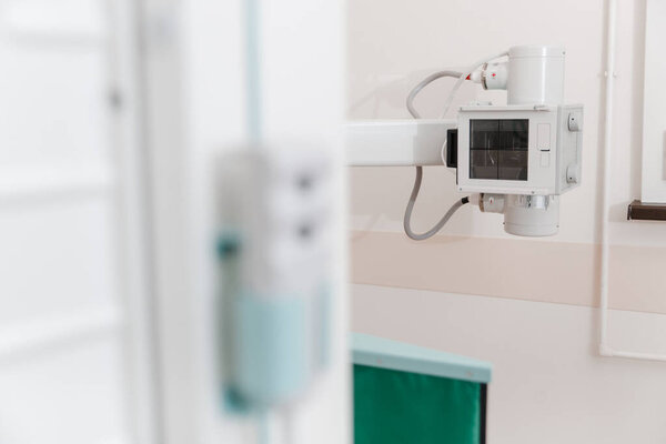 Больничная радиологическая комната. Рентгеновское отделение в современной больнице. Медицинское оборудование. сканирующая машина для флюорографии. Техник регулирует рентгеновский аппарат. Сканирование груди, сердца, легких в современной клинике.