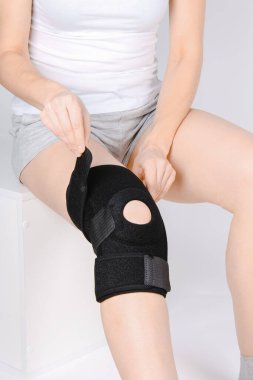 Diz Destek Kolu beyaz arka planda izole edilmiş bir bacak üzerinde. Elastik ortopedik ortopedi. Diz saplantısı, yaralanma ve ağrı için anatomik destek. Koruyucu diz eklemi bandaj kolu. Travma, rehabilitasyon.