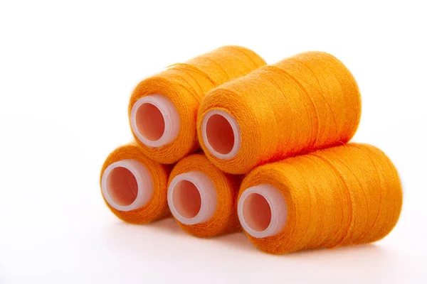 흰 바탕에 분리 된 오렌지 실감개. 모직 실의 정강. 뜨개 질을 좋아하지. 재봉틀 재료. 코일 — 스톡 사진