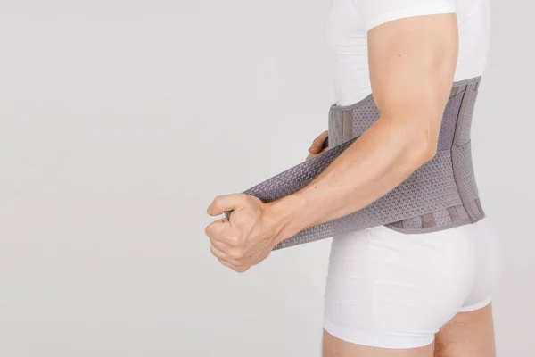 Lumbar brace on the human body isolated on a white background. Trauma of back. Back brace, orthopedic lumbar, support belt for back muscles. Lower back problems health Stock Picture
