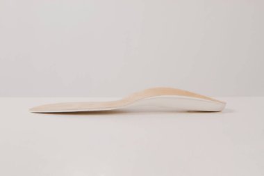 Beyaz arka planda izole edilmiş tabanlar. Tıbbi ortopedik tabanlar. Ayak bakımı. Kesik tabanlı katmanlar. Düz taban ve ayak hastalıklarının tedavisi ve önlenmesi. Ayakkabının iç tabanları