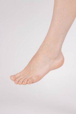 Beyaz arka planda yalınayak ve bacaklar izole. Sağlıklı, güzel kadın ayaklarının yakın çekimi. Sağlık ve güzellik konsepti. Tarafsız manikür ya da pedikür ile insan ayak kremi yan görüntüsü. Ayak tabanı.