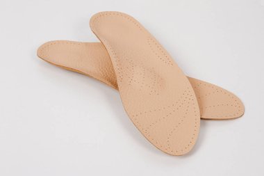 Beyaz arka planda izole edilmiş tabanlar. Tıbbi ortopedik tabanlar. Ayak bakımı. Kesik tabanlı katmanlar. Düz taban ve ayak hastalıklarının tedavisi ve önlenmesi. Ayakkabının iç tabanları