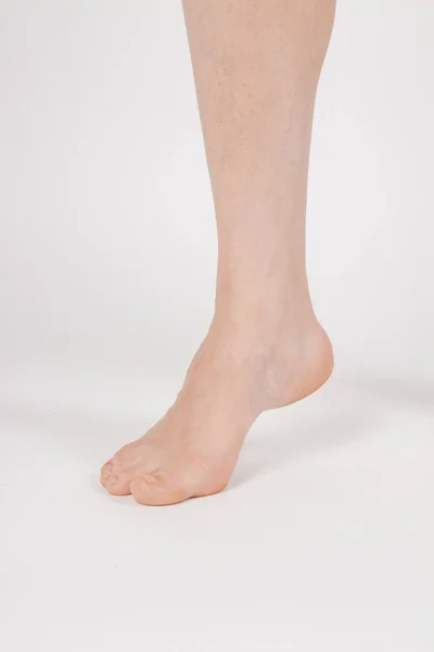Descalço e pernas isolados no fundo branco. close-up tiro de saudáveis belas pernas femininas. Conceito de saúde e beleza. Vista lateral do fio do pé humano com manicure neutro ou pedicure. Sola do pé — Fotografia de Stock