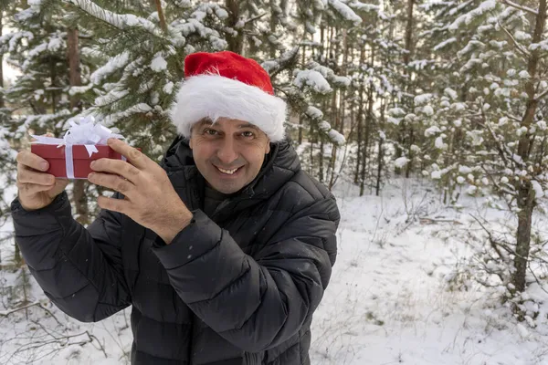 Мужчина Шляпе Санты Рождественским Подарком Зимой Лесу — стоковое фото