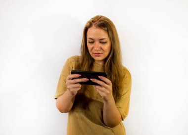 Akıllı telefonlu genç ve güzel bir kadın, bir mesaj yazıyor, selfie çekiyor, iletişim kuruyor.