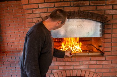 Adam barbekü yapıyor, fırında kebap pişiriyor.