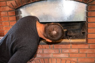 Adam barbekü yapıyor, fırında kebap pişiriyor.