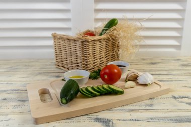 Sebzeler masada ve sepetin içinde, domatesler, salatalıklar, avokado, sarımsak ve zeytinyağı, vejetaryenlik, sağlıklı beslenme