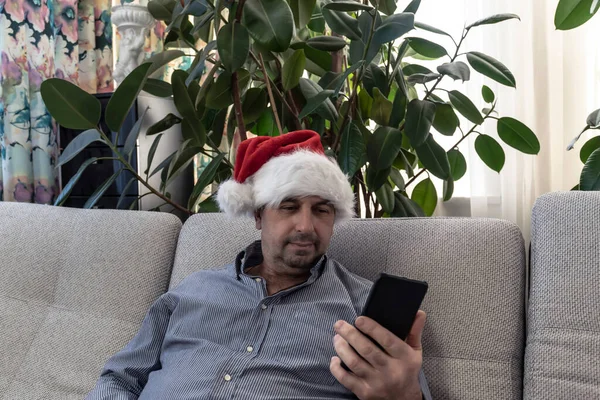 클로스 모자를 남자는 당신이 새해를 보내길 바라고 전화로 크리스마스를 합니다 — 스톡 사진