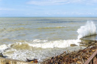 Fırtınadan sonra Karadeniz, kıyıda kahverengi su ve enkaz