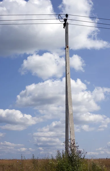 Hochspannungsleitung unter blauem Himmel mit weißen Wolken — Stockfoto