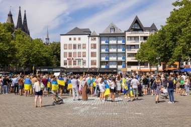 Cologne, Germany  July 30, 2022: Ukrainian protest against the Russian war in the Ukraine, on the Heumarkt square in Cologne. People holding placards and Ukrainian flags.