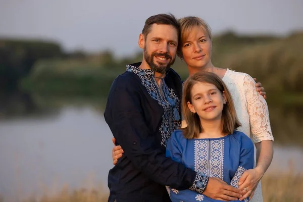 Geleneksel Ukrayna kıyafetleri içinde mutlu bir aile nehir kenarında (açık hava))
