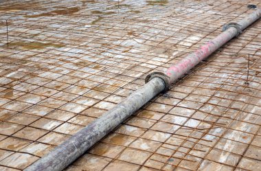 Çelik ağdaki demir boru ve inşaat sahasındaki kum. 