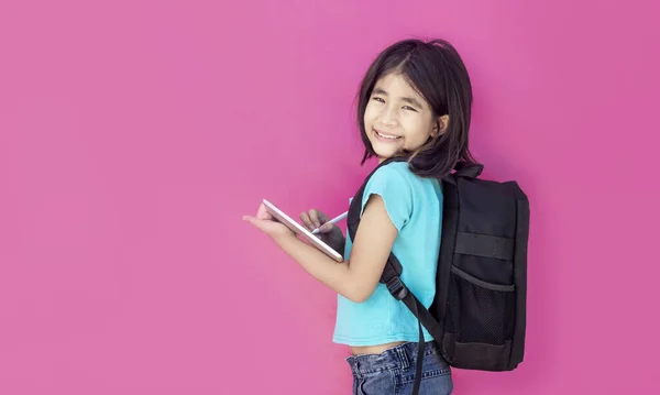 快乐的亚洲女孩学习平板电脑和互联网与书包粉红背景回到学校的概念 — 图库照片