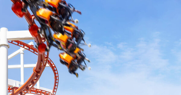 speed move and happy fun holiday of rollercoaster riding on clear summer sky