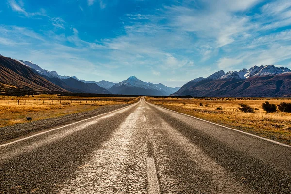 Yakınlaştır ve yolun sonunda fotoğraf çeken turistleri kontrol et. Pukaki Gölü, Aoraki Cook Dağı Ulusal Parkı 'ndaki Hooker Vadisi' ne gidiyor.