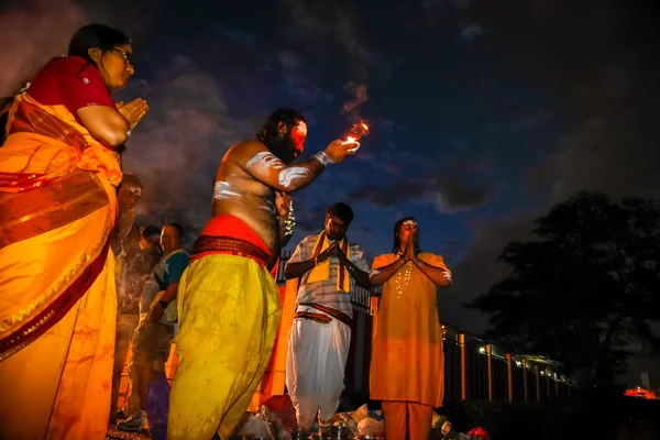 KUALA LUMPUR - 27 GENNAIO: Un sacerdote indù prega per Lord Muruga con una famiglia all'alba al tempio delle grotte Batu in Malesia il 27 gennaio 2013 durante il festival di Thaipusam . — Foto Stock