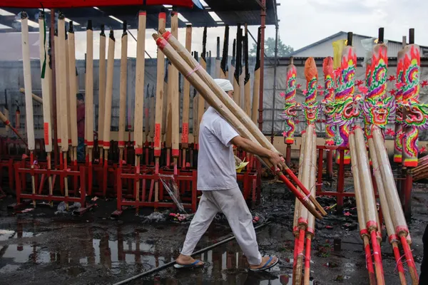 Temple worker carries giant candles — Stock Photo, Image