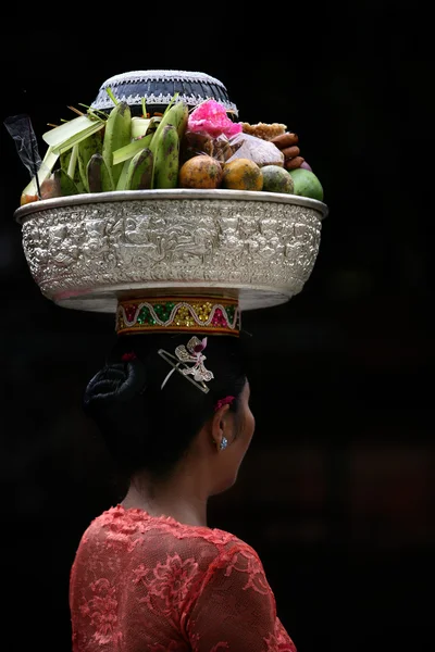 Una dama balinesa lleva una cesta de frutas — Foto de Stock