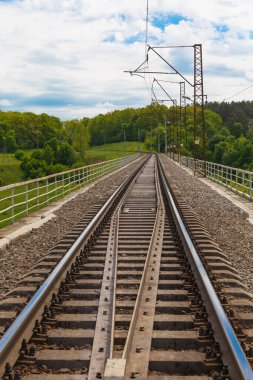Parlak bir yaz gününde Sluch nehri üzerindeki tren yolu köprüsü. Köprü yapısı, raylar yakın. Novohrad-Volynskyi şehri. Ukrayna