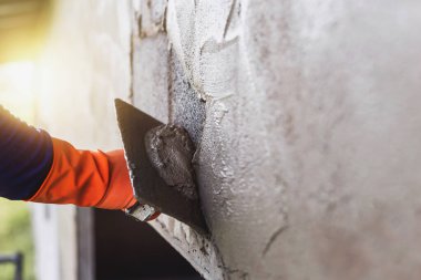 Beton alçıcılar endüstriyel işçilerin arka plan duvarlarını alçılama araçlarıyla donatmak için.