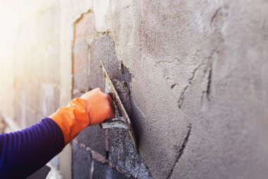 Beton alçıcılar endüstriyel işçilerin arka plan duvarlarını alçılama araçlarıyla donatmak için.
