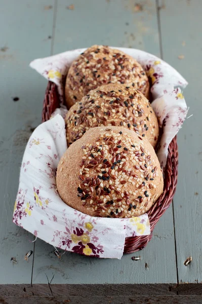 Wholegrain buns with flax and sesame seeds in the basket — Stock Photo, Image