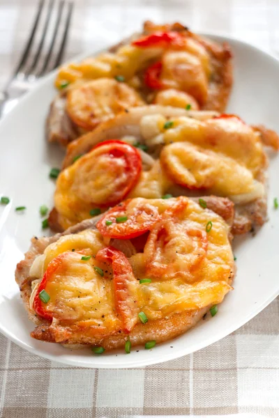 Varkensvlees met ui, cherry tomaten en kaas — Stockfoto