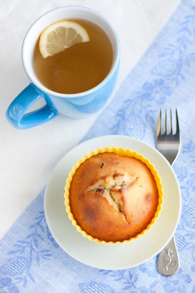 Muffin de iogurte com passas e chá verde com limão — Fotografia de Stock