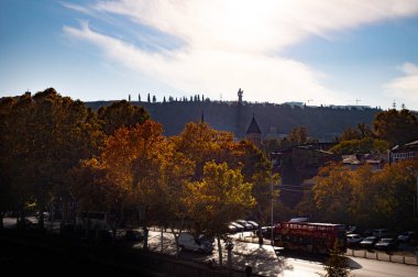 Köprüden Tiflis şehrine güzel bir manzara. Nehir tramvayı yüzüyor.